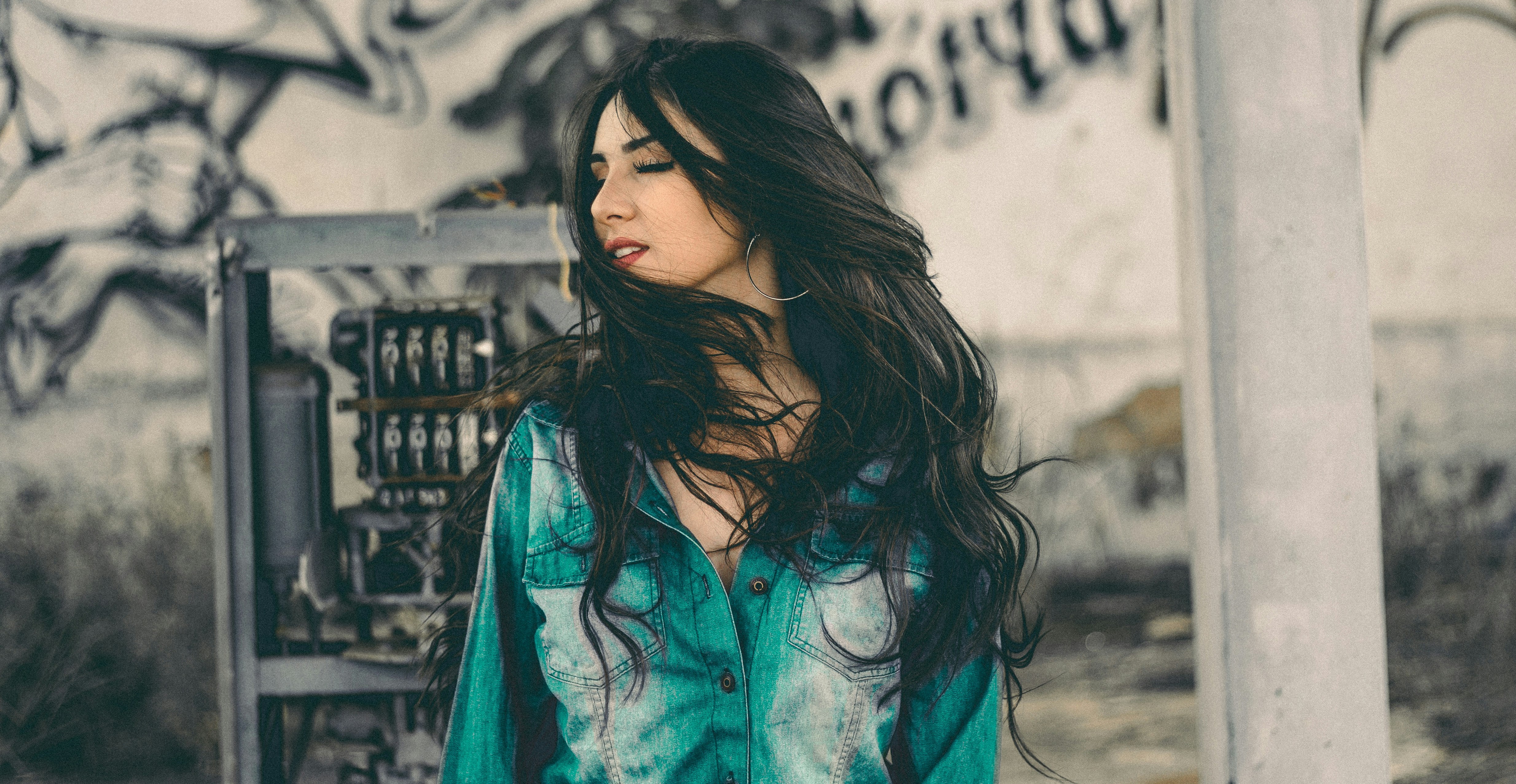 woman in teal and white top outdoors.