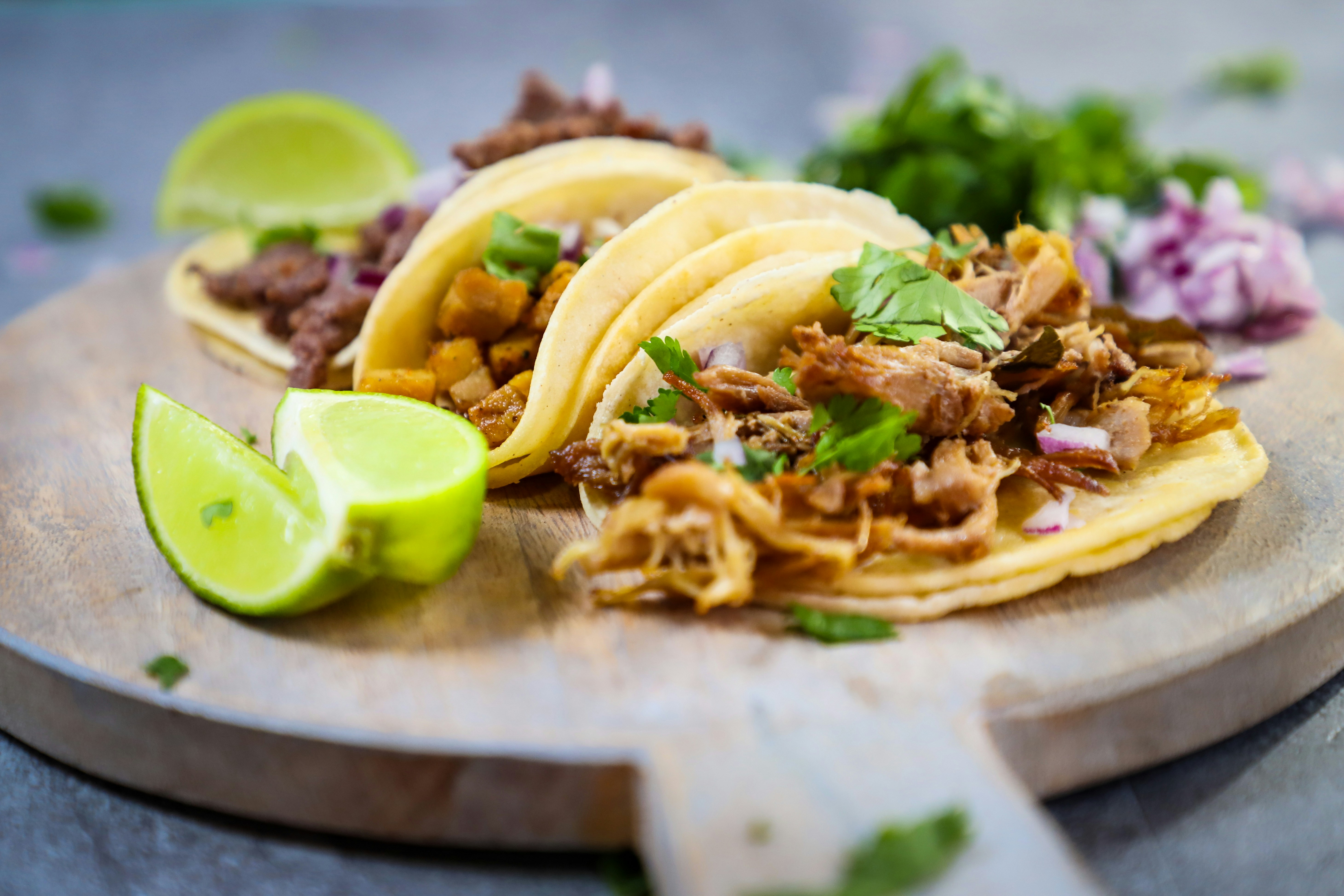 Plate of authentic Mexican street tacos with lime wedges and salsa